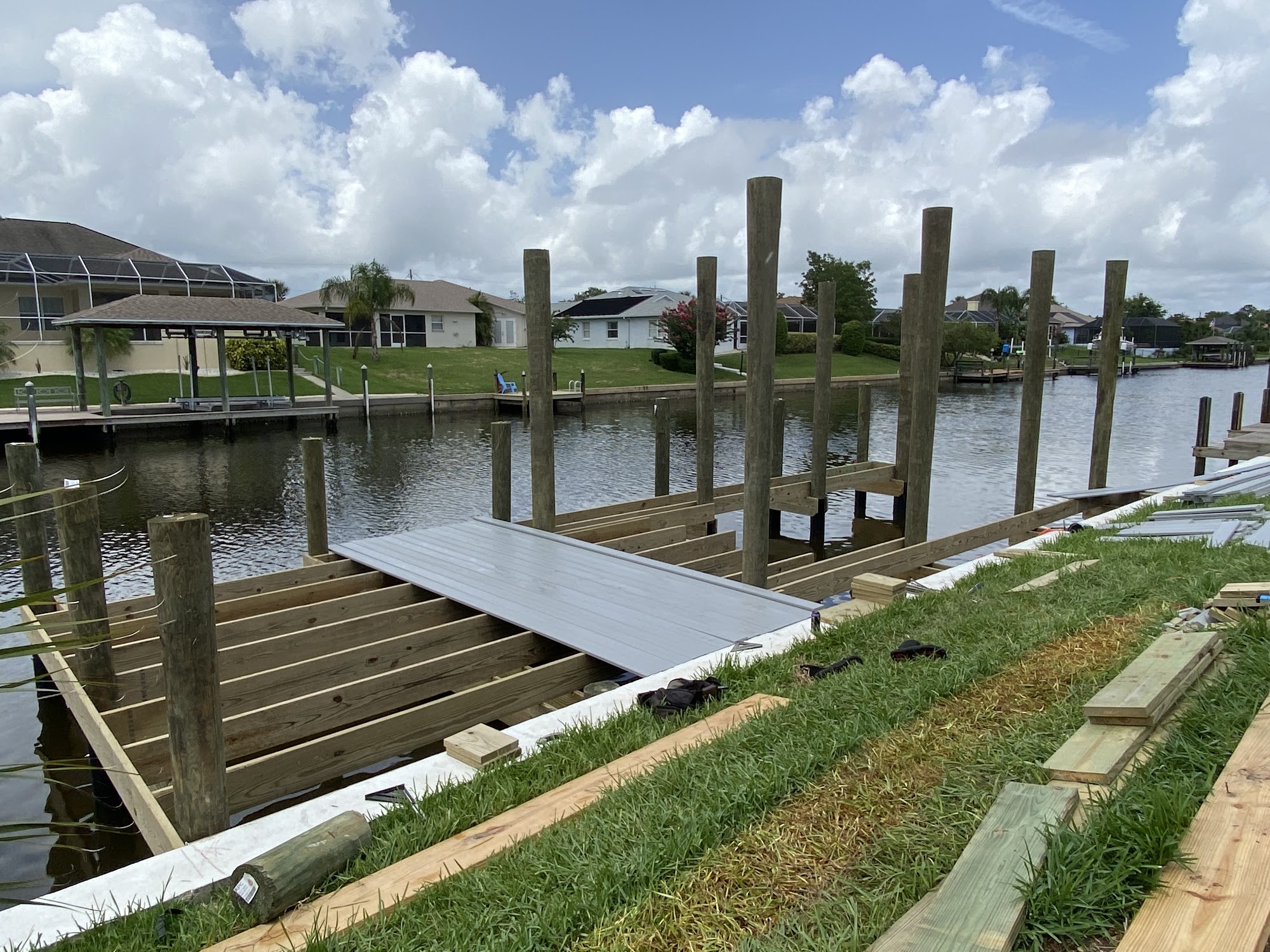 A dock under construction on a Palm Coast canal, pilings set and framing started